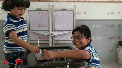 مواطنون يحتفلون مع أولادهم خلال التصويت في الانتخابات الرئاسية بالإسكندرية