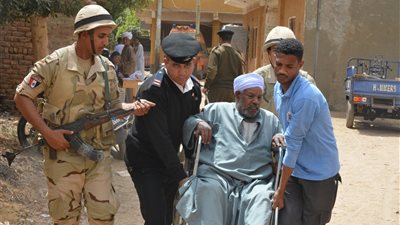 قوات تأمين المقار الانتخابية بأسوان يساعدون كبار السن في الوصول إلى اللجان (صور)