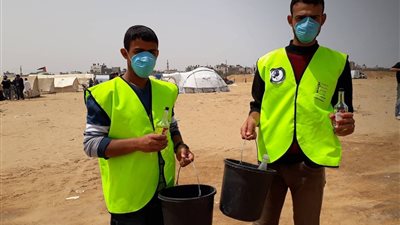 صور| شباب فلسطينييون يتطوعون لمكافحة قنابل الاحتلال فى جمعة 