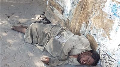 صور| متسول يلجأ للنوم في الشارع بموقف عبود 