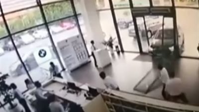 شاهد سيدة تحطم وكالة سيارات لتركن سيارتها