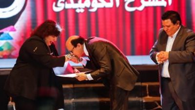 مجدى صبحى يقبل يد وزيرة الثقافة بعد تكريمه 