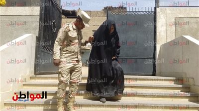 جندي يساعد«مسنة» فى الدخول والخروج من اللجنة اثناء الاستفتاء فى سوهاج