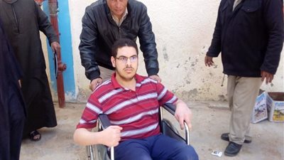 شرطي يساعد قعيد على الأدلاء بصوته فى الاستفتاء بالغربية 