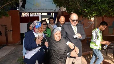 محافظ أسيوط يصطحب سيدة مسنة إلى داخل لجنة مدرسة الفاروق المتميزة للإدلاء بصوتها بالانتخابات الرئاسية