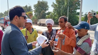 نائب محافظ سوهاج يوزع مواد غذائية وزجاجات مياه وأغطية رأس على عمال النظافة